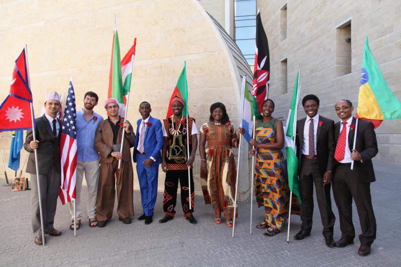 2016 IMPH graduates in traditional dress proudly show the flags of their countries
